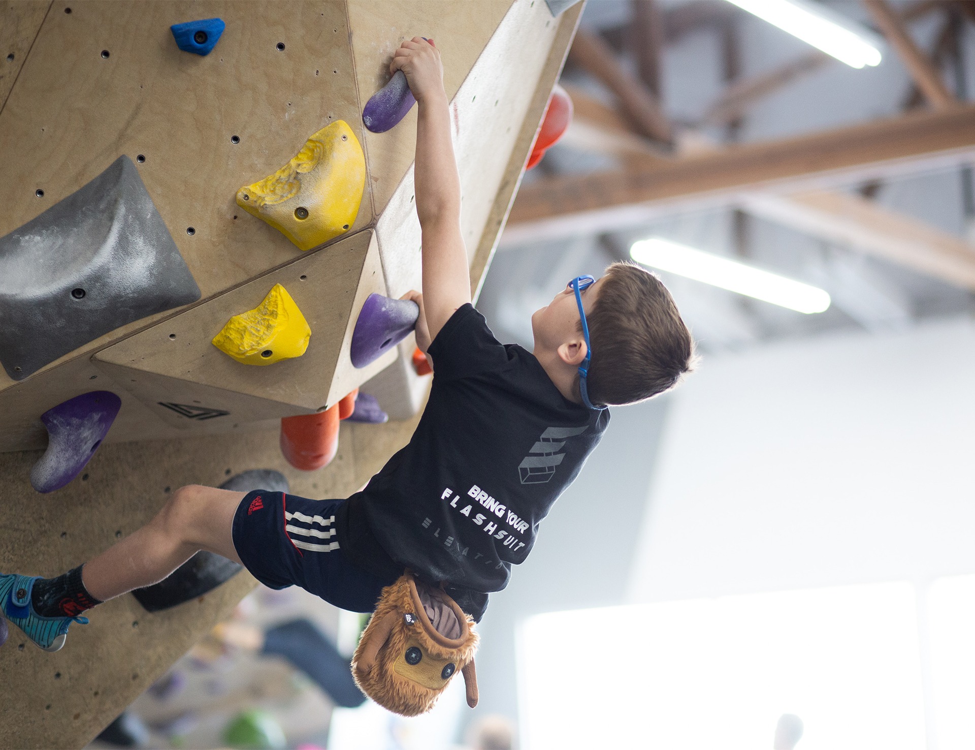A kid climbing at the gym